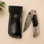 Engraved Damascus-Style Folding Knife with Black Handle & Leather Sheath